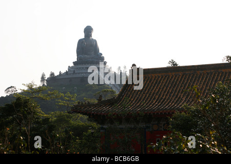 Tian Tan Buddha on Lantau Island, Hong Kong in front of the roof of a building in the Po Lin Monastery . Stock Photo
