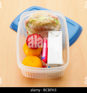 Healthy lunch box with wholemeal roll, satsumas, mini light cheese, orange juice and biscuit. Stock Photo
