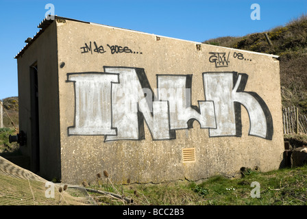A derelict concrete shed that has had graffiti sprayed onto it. Stock Photo