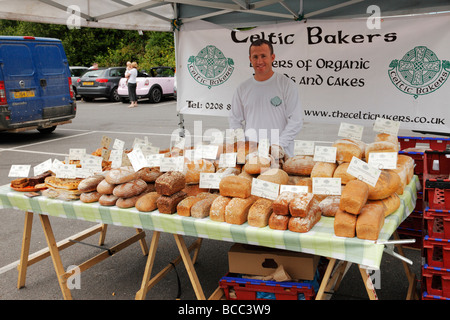 Man selling bread for sale at local farmers market. Westerham, Kent, England, UK. Stock Photo