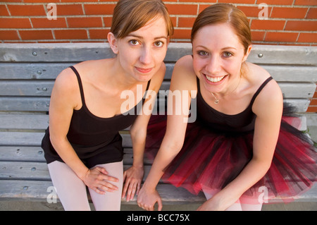 Two smiling Ballerinas sitting on a bench Stock Photo