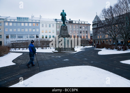 Man with a walking stick walking on Austurvollur city square Stock Photo