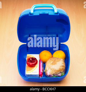 A children's school healthy lunch box / packed lunch with wholemeal roll, two satsumas fruit, light cheese, orange juice and a sweet biscuit. Stock Photo