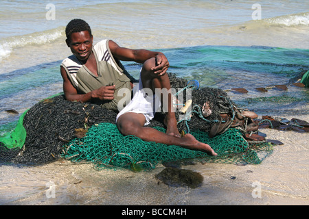 Malagasy Fisherman Resting On His Nets On Ifaty Beach, Madagascar Stock Photo