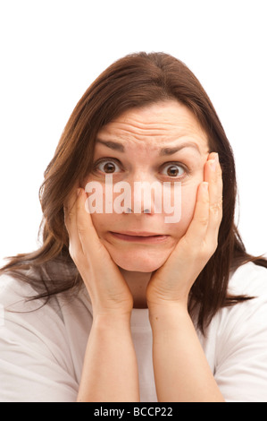 A woman holding her head in her hands looking horrified scared worried distraught shocked Stock Photo