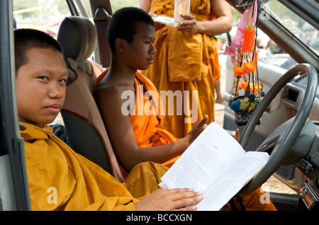 three Happy Buddhist monks reading in their car in Bangkok Thailand Stock Photo