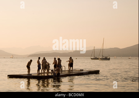 Teenagers on a floating dock at dusk, swimming, Vancouver, British Columbia, Canada Stock Photo