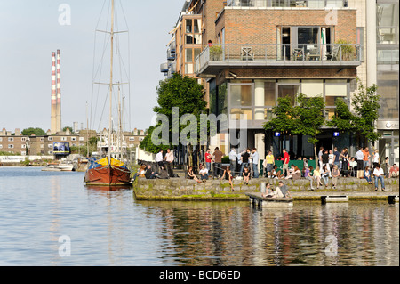 People relaxing in the sun outside bar at Grand Canal Dock Dublin Republic of Ireland Stock Photo