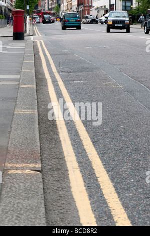 Double yellow line on street London England UK Stock Photo