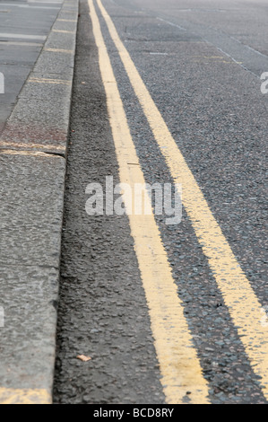 A close up of double yellow line kerbside road markings Stock Photo - Alamy