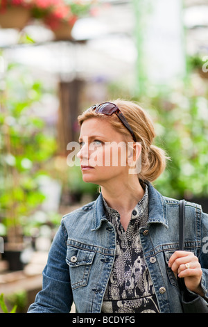 Portrait, blond woman in a greenhouse. Stock Photo