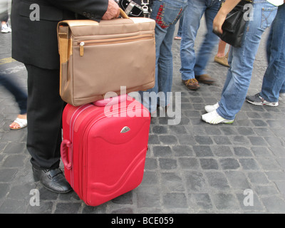 businessman with luggage standing in street in city town Stock Photo