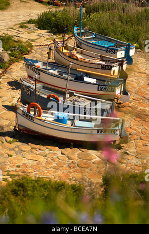 A row of small fishing boats on the cobbled slipway at Penberth Cove in Cornwall UK Stock Photo