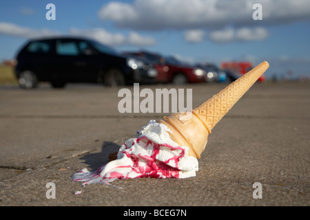 ice cream cone dropped onto pavement in a car park Stock Photo