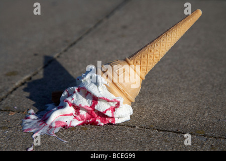 melting ice cream cone dropped onto pavement or thrown onto ground in the uk Stock Photo