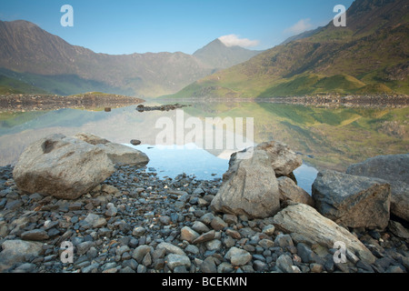 Snowdon in the dawn light reflected in the surface of Llyn Llydaw reservoir, on the Miners Path, Snowdonia, North Wales, UK Stock Photo