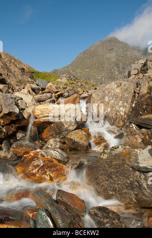 Snowdon in the early morning light with Afon Glaslyn in the foreground as it tumbles over boulders close to Glaslyn on the Miner Stock Photo