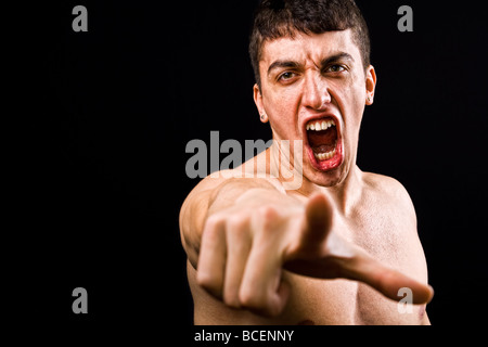Loud scream of angry furious violent man pointing towards camera Stock Photo