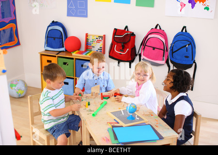 Four kids playing in preschool classroom Stock Photo