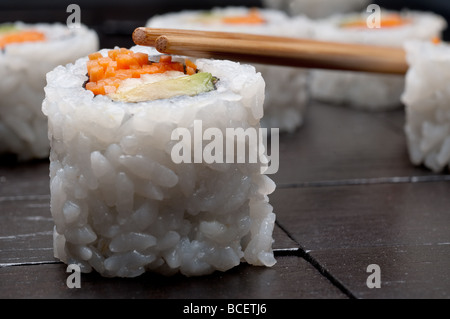horizontal shallow focus macro of sushi with copsticks on a black wooden background Stock Photo