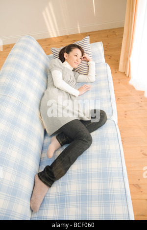 Young woman lying on sofa Stock Photo