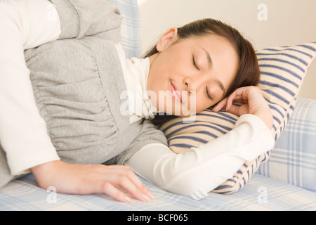 Young woman lying on sofa Stock Photo