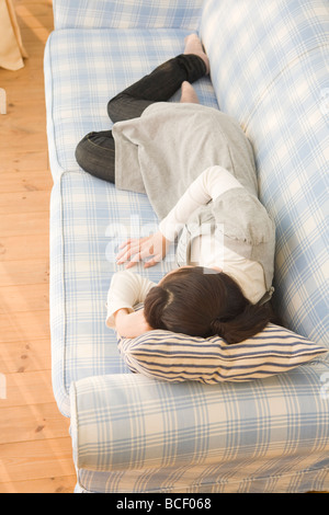 Young woman lying on sofa Stock Photo