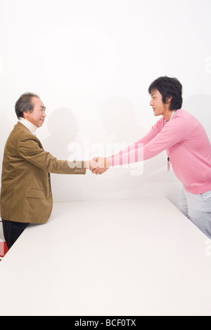 Mature man and young man shaking hands Stock Photo
