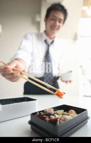 Businessman cooking in lunch box Stock Photo