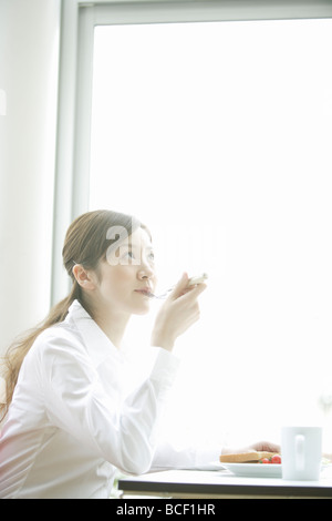 Young woman eating breakfast Stock Photo