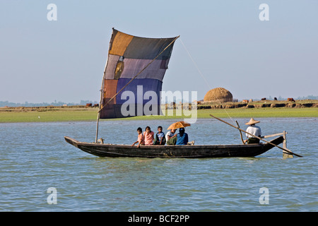 Myanmar, Burma, Kaladan River. A traditional sailing boat on the Kaladan River with cattle and a haystack of rice straw. Stock Photo