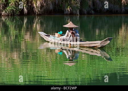 Myanmar, Burma, Lay Mro River. A Rakhine man fishes from a small wooden boat in the still waters of the Lay Myo River. Stock Photo