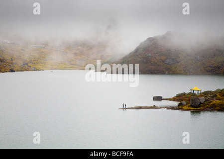 India, Sikkim, Gangtok, Tsomgo Lake, Tourists standing by lakeside Stock Photo