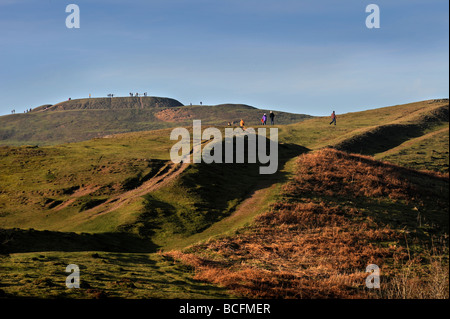 WALKERS ON BRITISH CAMP AN IRON AGE HILL FORT ON THE MALVERN HILLS ON AN EARLY SPRING EVENING UK Stock Photo
