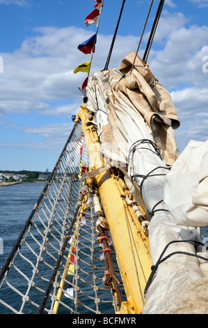 Bowsprit on sailing tall ship with furled sails rope shroud and flags Stock Photo