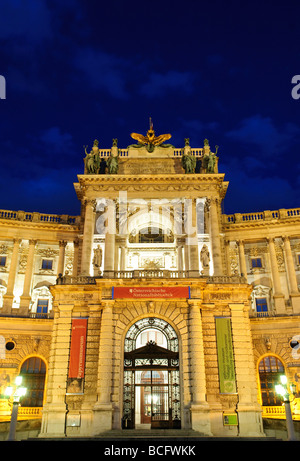 VIENNA, Austria — The majestic Hofburg Palace glows in the fading light of dusk. The ornate Baroque architecture of the former imperial residence is illuminated against the darkening sky, reflecting centuries of Habsburg power in the heart of Vienna. Stock Photo