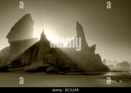 Sea stacks at Bandon Beach with fog and sun rays Oregon Stock Photo