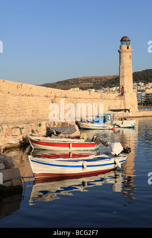 Fishing dinghies moored in front of the lighthouse in Rethymnon harbour Crete Greece July 7 2009 Stock Photo