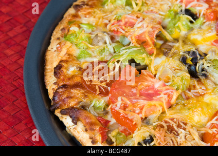 A close up of a freshly baked hot pizza with fresh tomato pepperoni bel pepper and cheese Stock Photo