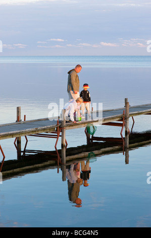 Family on wooden pier overlooking Puck Bay early evening Hel Peninsula Baltic Sea Poland Stock Photo