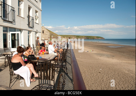 Holidaymakers sitting on the terrace of the Ty Newydd Hotel overlooking the beach at Aberdaron village Stock Photo