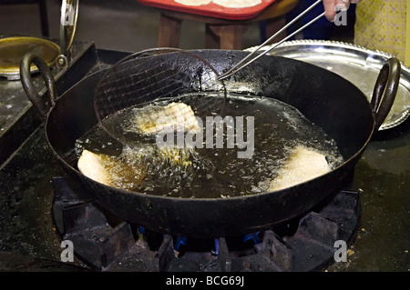 poppadoms being deep fat fried in a hindu temple in the uk in their communal kitchen Stock Photo