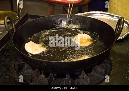 poppadoms being deep fat fried in a hindu temple in the uk in their communal kitchen Stock Photo