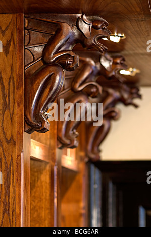 carved wooden supports in a pub on shelves carved and shaped like gargoyles as pub decoration Stock Photo