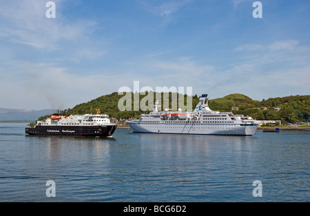 Caledonian MacBrayne car ferry Clansman returning to Oban in Scotland with cruise liner Astor anchored in the harbour Stock Photo