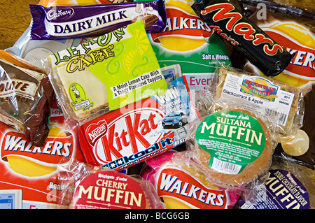 a selection of snacks like crisps and chocolate on sale at a small delicatessen Stock Photo