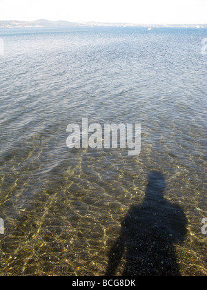 person's shadow in lake water surface Stock Photo