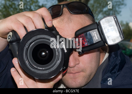 Close up of a man using a canon digital slr camera and flash Stock Photo