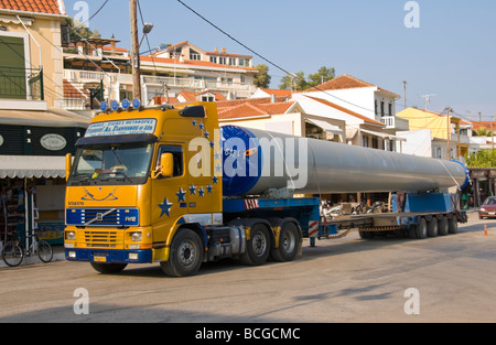 Wind turbine mast being transported on lorry by road through Agia Efimia port on the Greek island of Kefalonia Greece GR Stock Photo