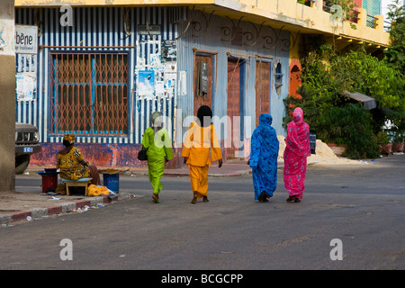 Colorfully dressed women walking on a street in Saint Louis Senegal Stock Photo